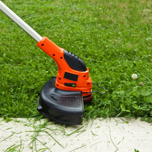 Lawn care professional using a string trimmer on the grass.