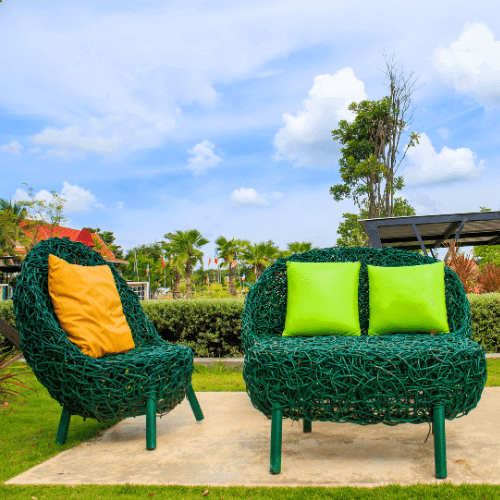 Green woven chairs with colorful cushions.